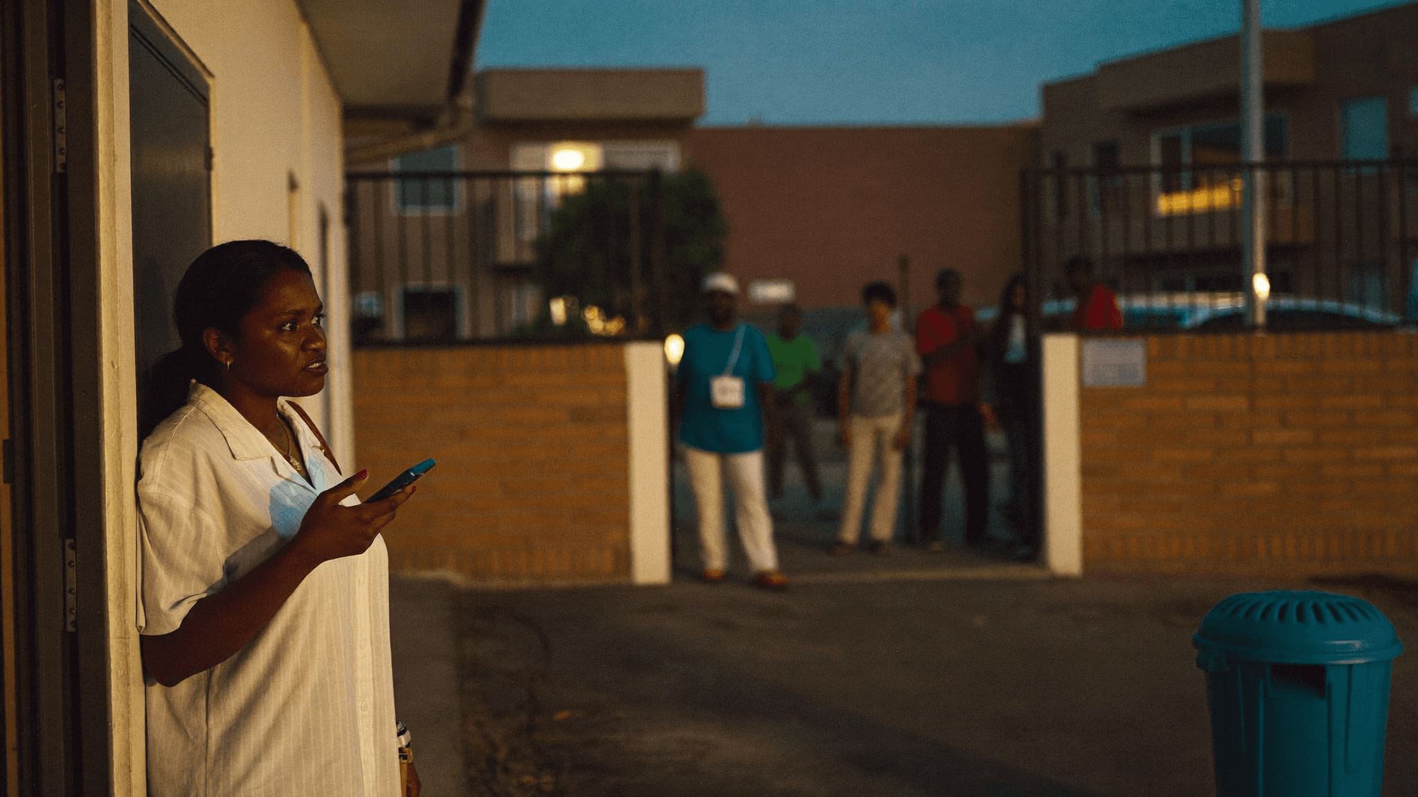 South African apartment resident safely checking her phone after a neighbourhood disturbance